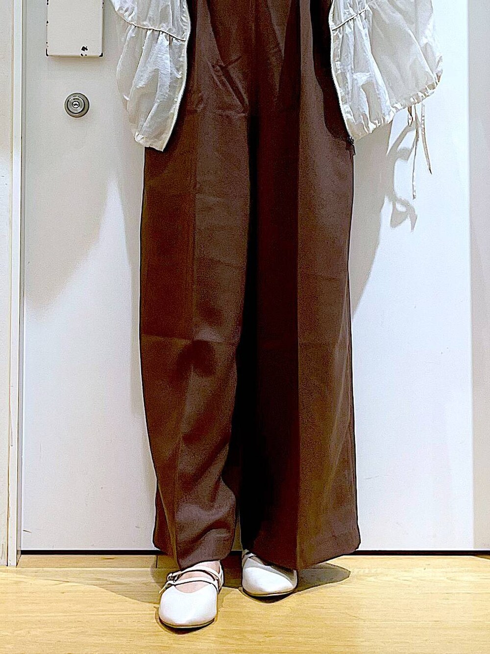 ホワイト系のショルダーバッグ、ホワイト系のパンプス、ブラック系のTシャツ/カットソーを着用したレディースの秋コーディネートの8枚目の写真