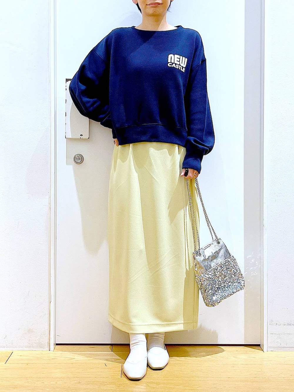 ホワイト系のパンプス、ブルー系のTシャツ/カットソー、イエロー系のスカートを着用したレディースの春コーディネートの6枚目の写真