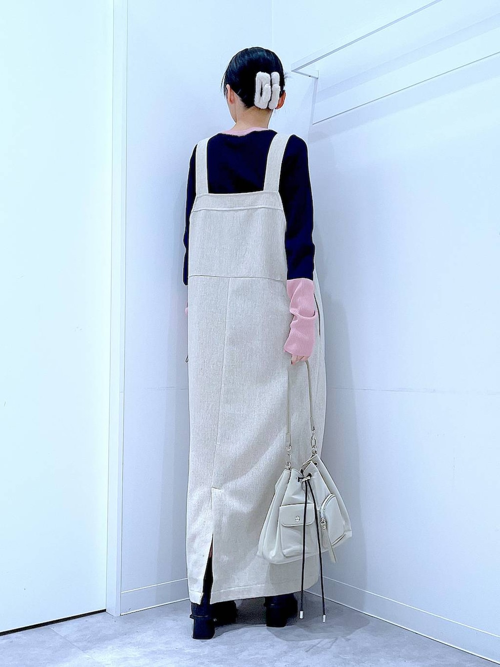 ブラック系のブーツ、ベージュ系のジャンパースカート、ブルー系のニット/セーターを着用したレディースの冬コーディネートの5枚目の写真