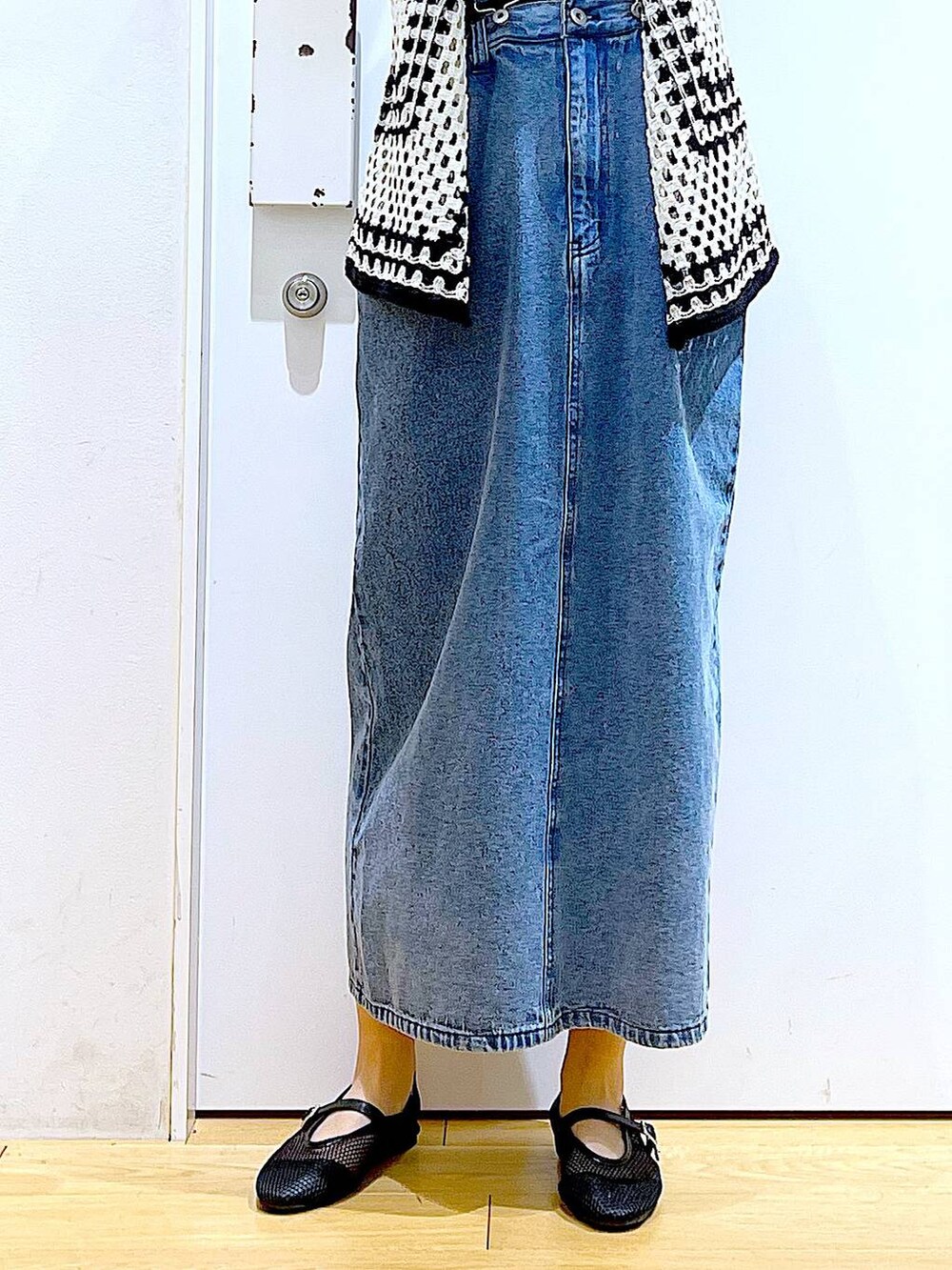 ブラック系のショルダーバッグ、ブラック系のパンプス、ブルー系のジャンパースカートを着用したレディースの春コーディネートの8枚目の写真