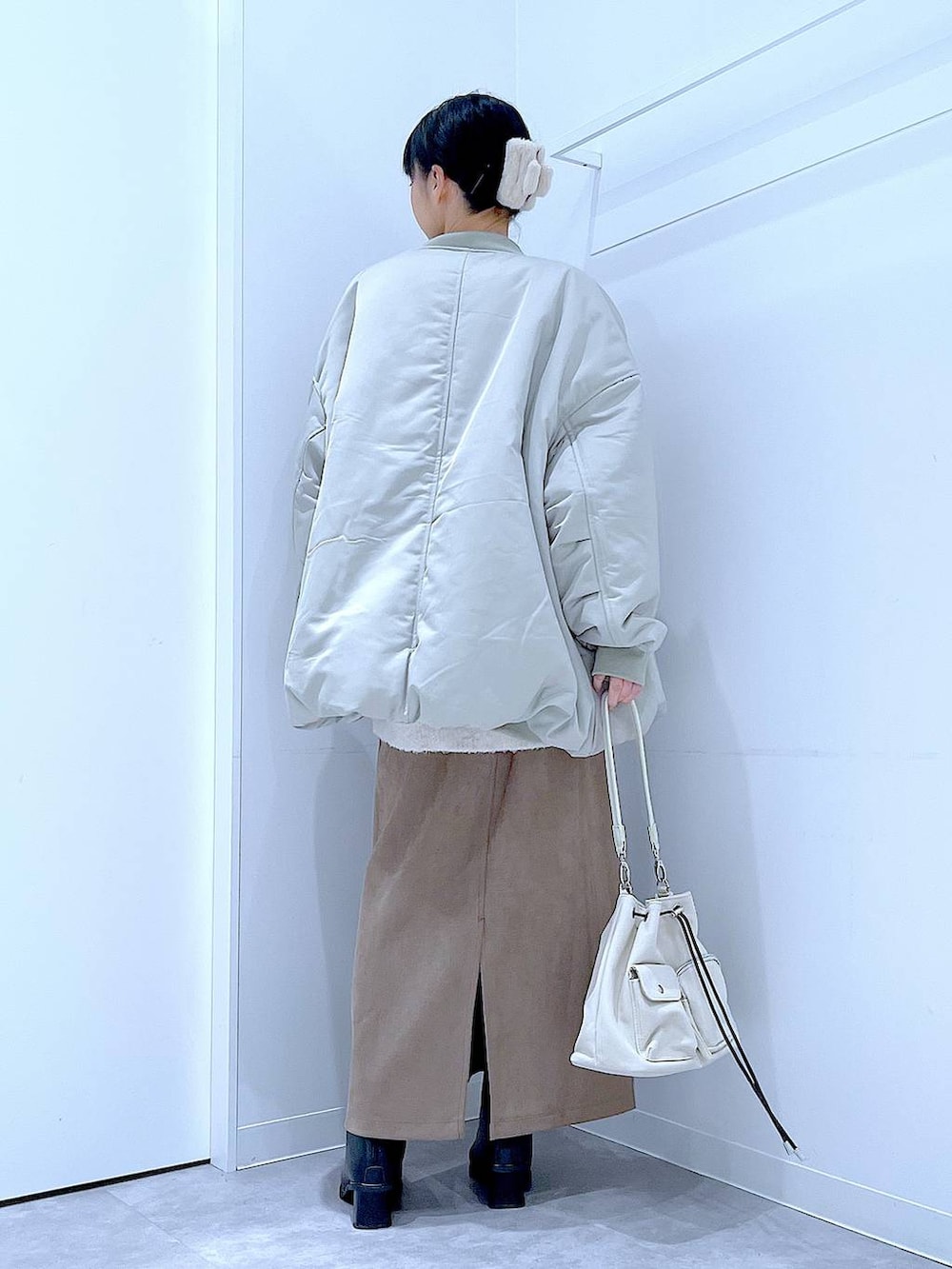 ベージュ系のニット/セーター、ブラック系のブーツ、ブラウン系のスカートを着用したレディースの冬コーディネートの5枚目の写真