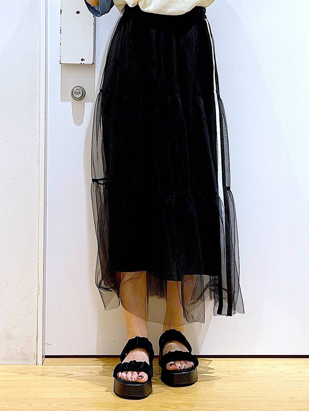 ブラック系のサンダル、ブルー系のTシャツ/カットソー、ブラック系のスカートを着用したレディースの夏コーディネートの8枚目の写真