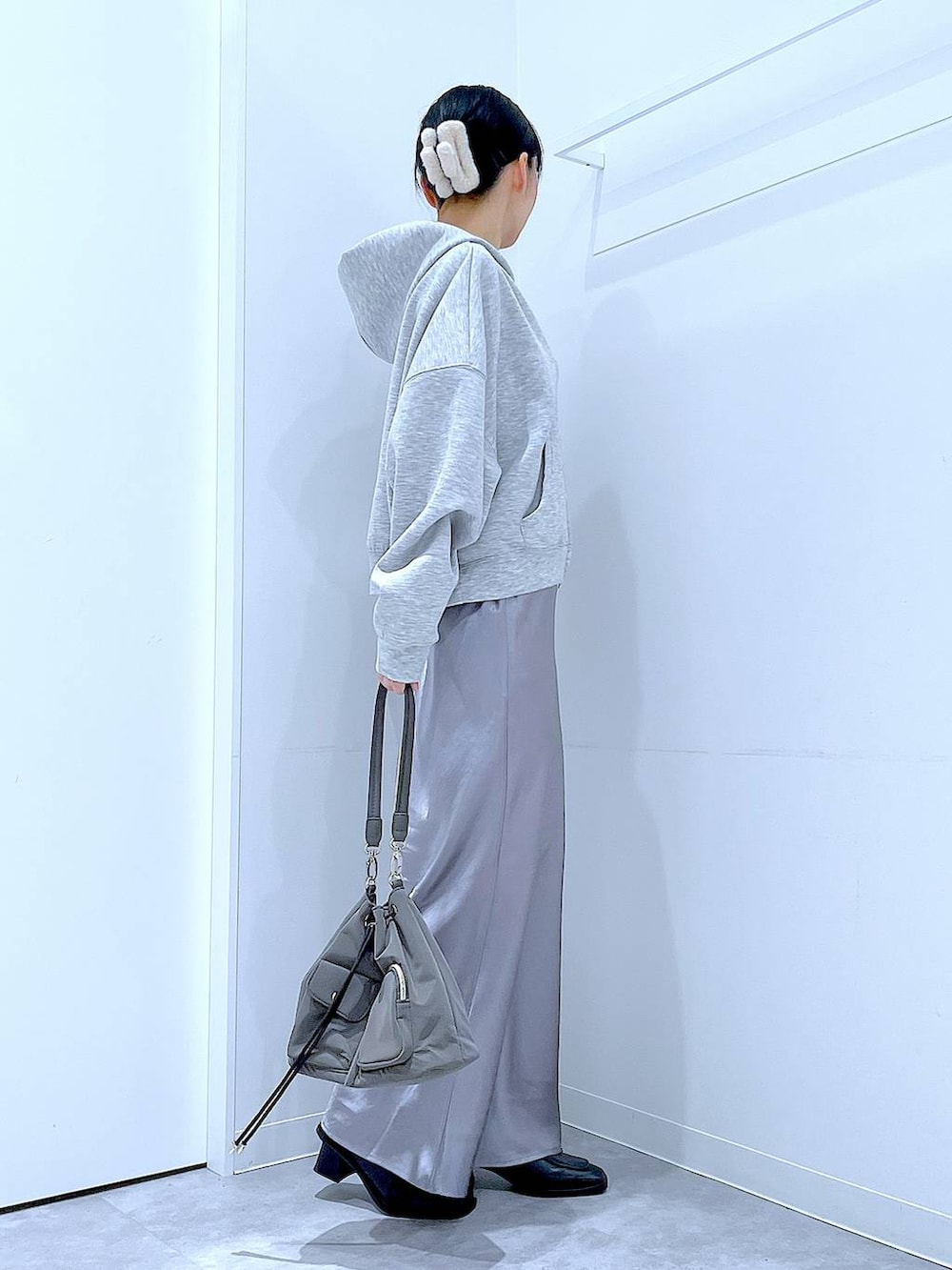 ブラック系のブーツ、グレー系のスカート、グレー系のパーカーを着用したレディースの春コーディネートの4枚目の写真