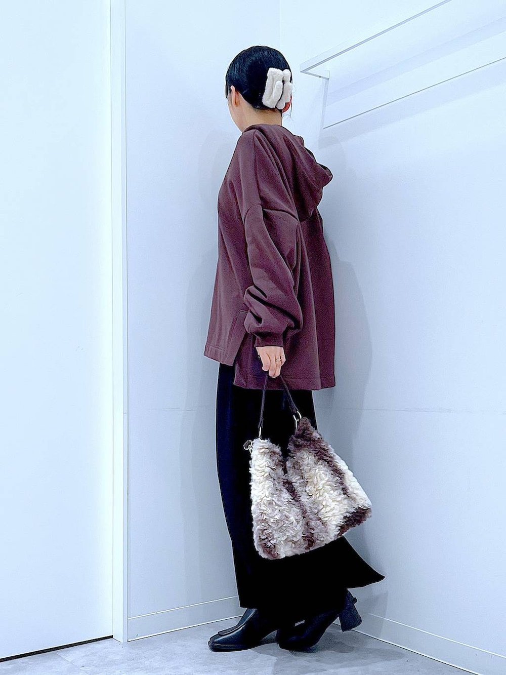 ブラック系のブーツ、ブラウン系のショルダーバッグ、ブラック系のスカートを着用したレディースの冬コーディネートの3枚目の写真