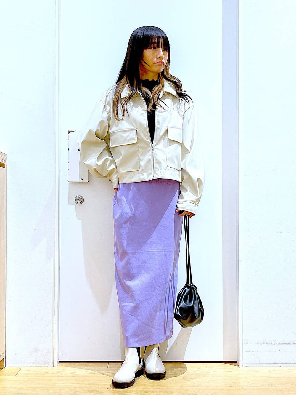 ベージュ系のブルゾン、ブラック系のTシャツ/カットソー、ベージュ系のブーツを着用したレディースの冬コーディネートの2枚目の写真