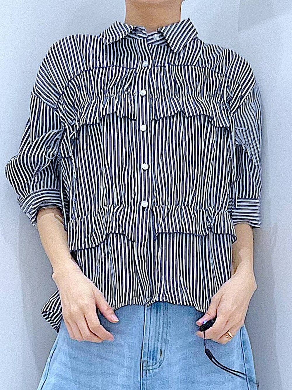 ブルー系のデニムパンツ、ベージュ系のトートバッグ、ホワイト系のスニーカーを着用したレディースの夏コーディネートの7枚目の写真