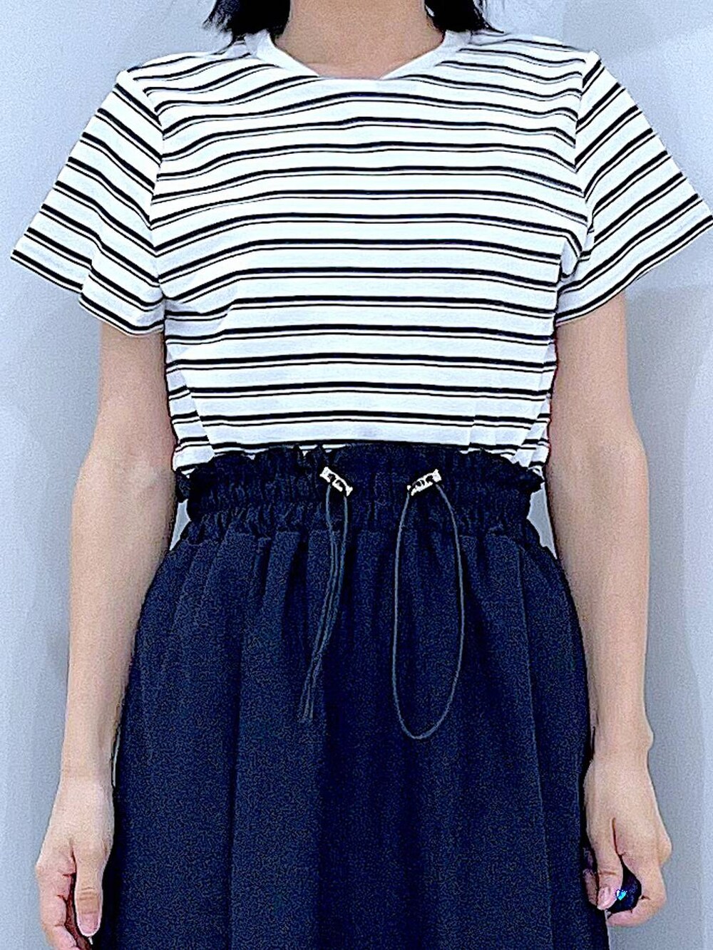 ホワイト系のショルダーバッグ、ホワイト系のサンダル、ベージュ系のTシャツ/カットソーを着用したレディースの夏コーディネートの7枚目の写真