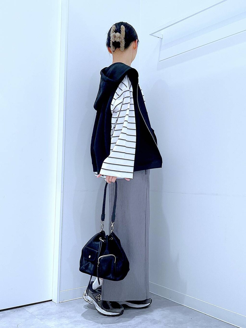 ブラック系のショルダーバッグ、ホワイト系のTシャツ/カットソー、グレー系のスカートを着用したレディースの春コーディネートの4枚目の写真