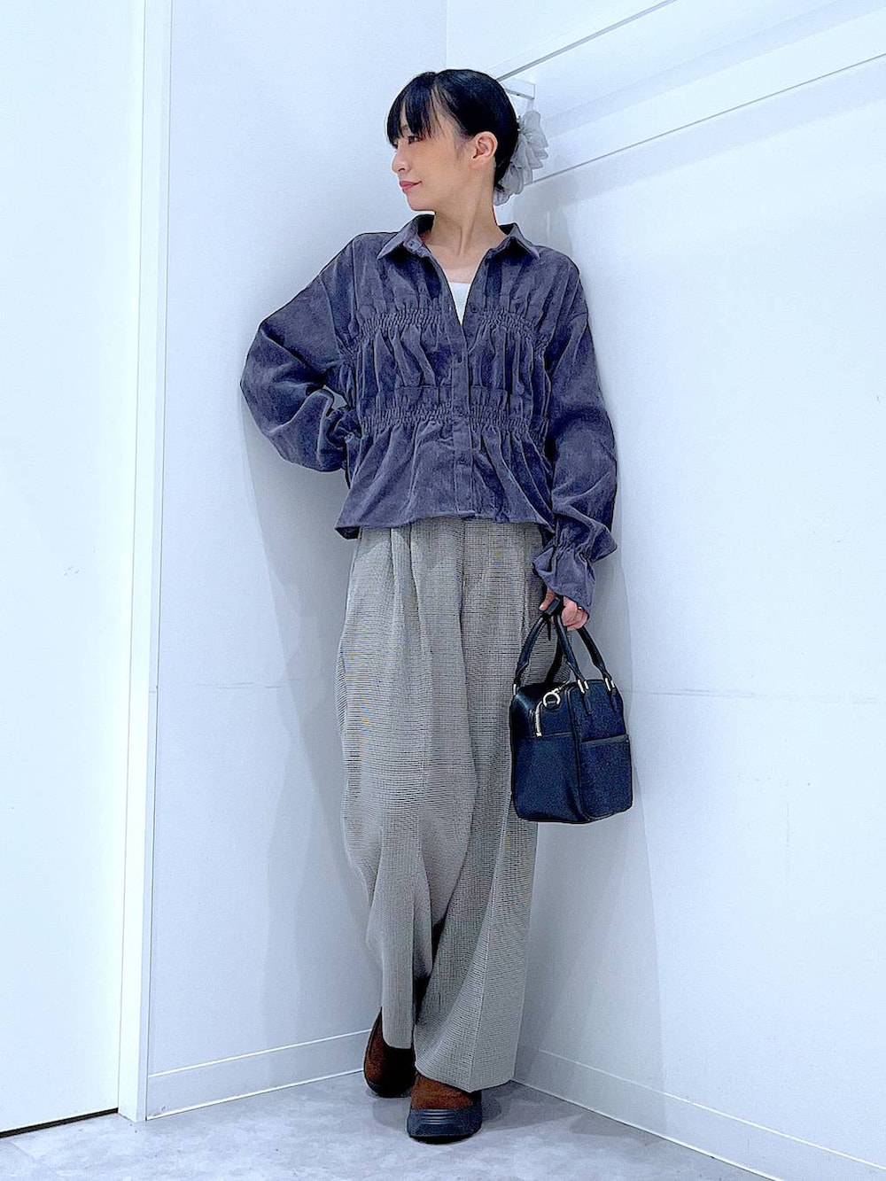 ベージュ系のスラックス、グレー系のシャツ/ブラウス、ブラック系のボストンバッグを着用したレディースの秋コーディネートの2枚目の写真