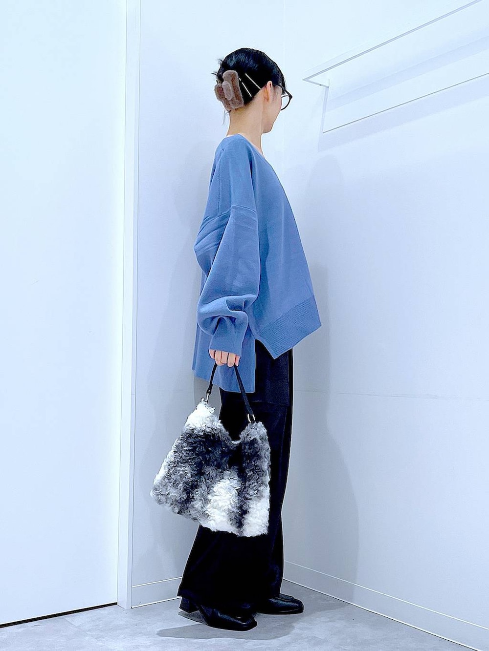 ブルー系のニット/セーター、ブラック系のブーツ、ブラック系のショルダーバッグを着用したレディースの冬コーディネートの4枚目の写真