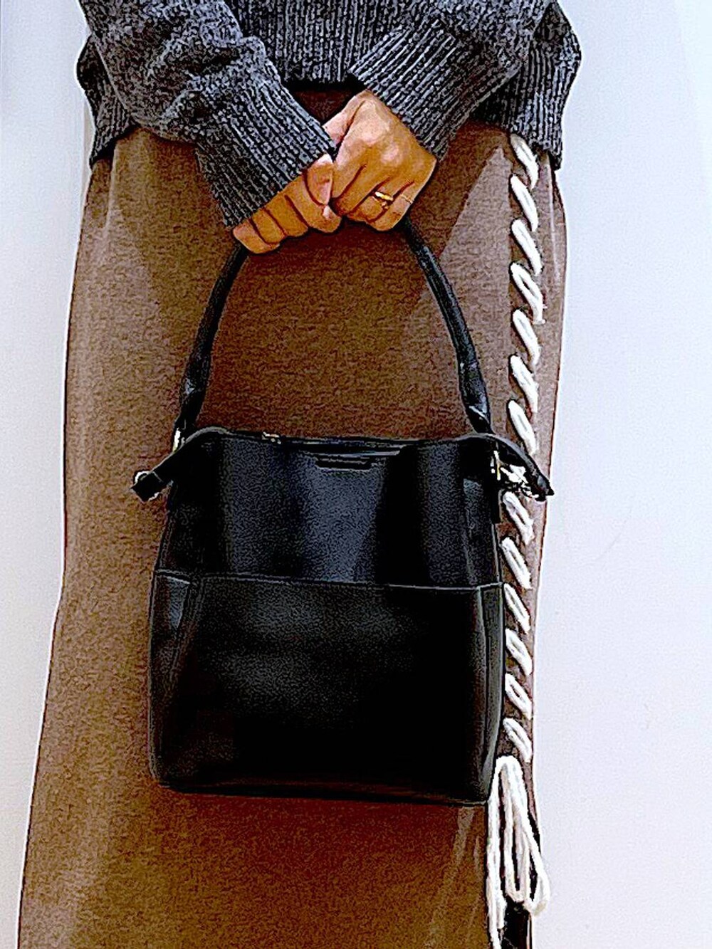 ブラック系のブーツ、ブラック系のショルダーバッグ、ブラウン系のスカートを着用したレディースの冬コーディネートの9枚目の写真