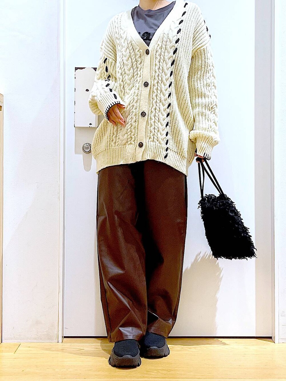 ブラック系のショルダーバッグ、グレー系のTシャツ/カットソー、ブラック系のブーツを着用したレディースの秋コーディネートの6枚目の写真