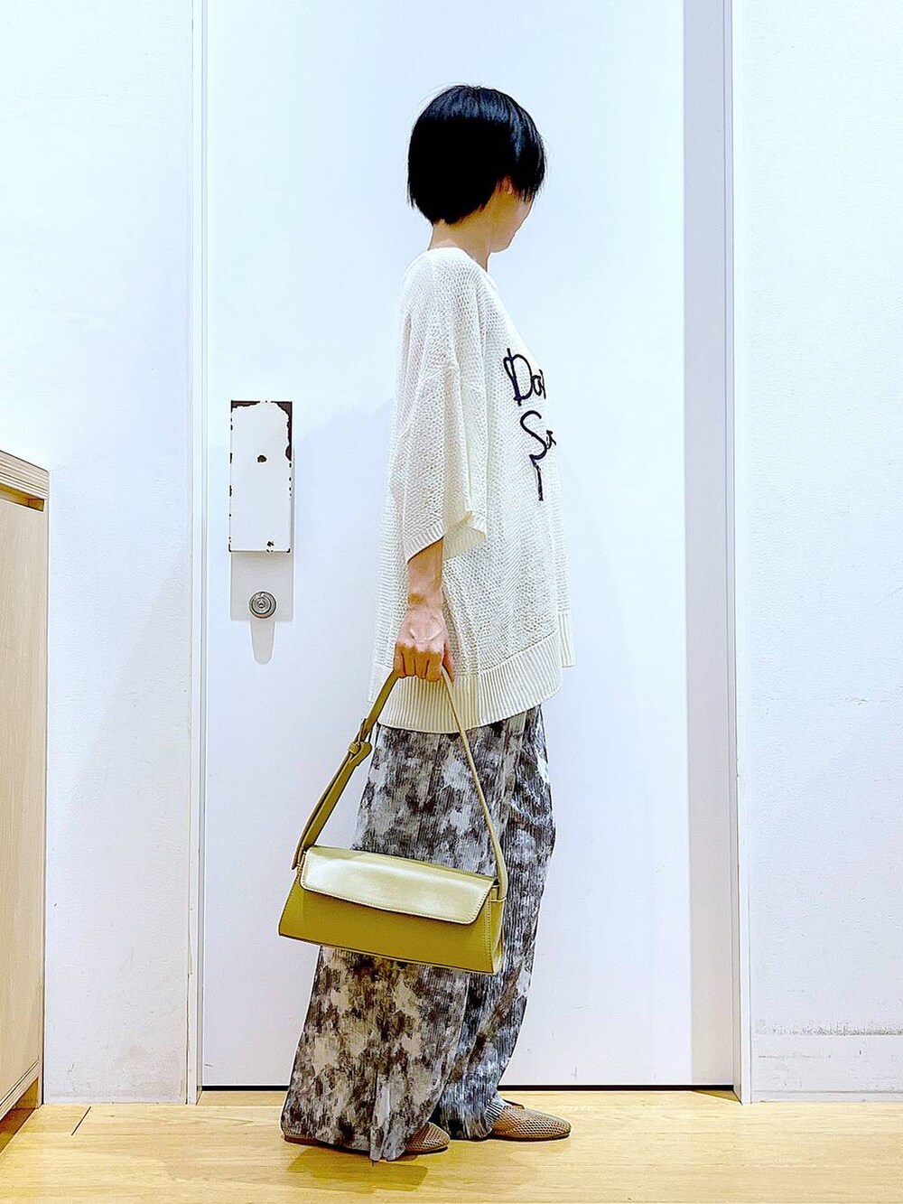 ベージュ系のパンプス、イエロー系のショルダーバッグ、グレー系のその他パンツを着用したレディースの春コーディネートの4枚目の写真