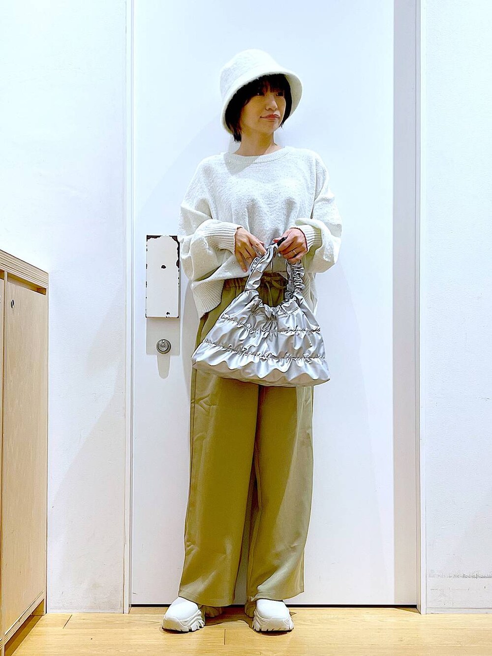 ベージュ系のブーツ、イエロー系のその他パンツ、シルバー系のショルダーバッグを着用したレディースの冬コーディネートの2枚目の写真