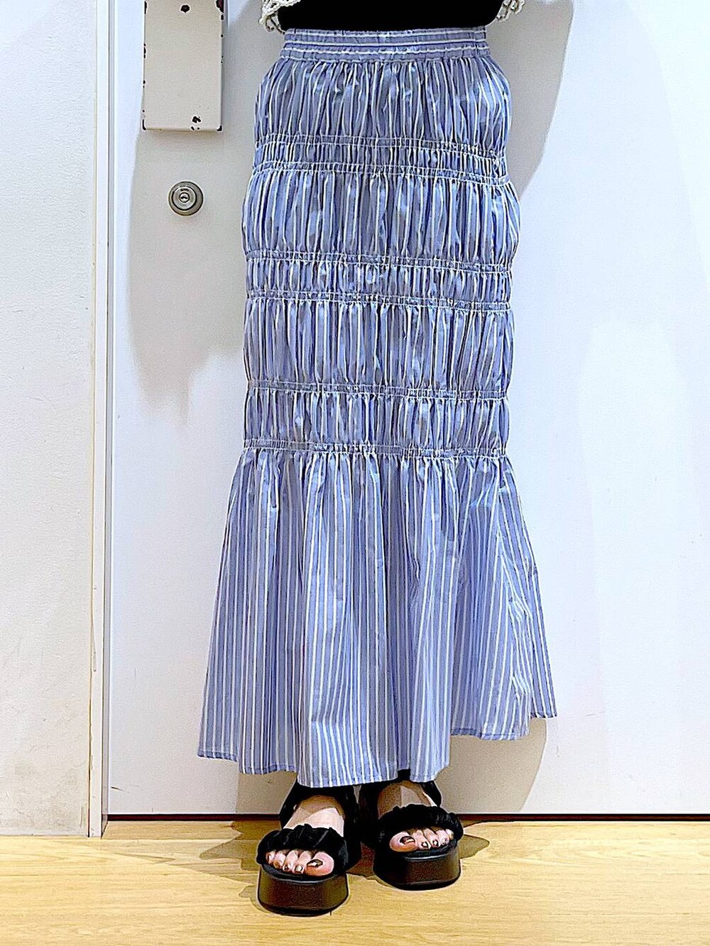 ブラック系のサンダル、ホワイト系のベスト、その他のスカートを着用したレディースの夏コーディネートの8枚目の写真