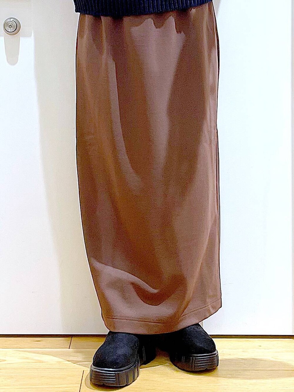 ブラック系のブーツ、ベージュ系のショルダーバッグ、ブラウン系のスカートを着用したレディースの冬コーディネートの8枚目の写真