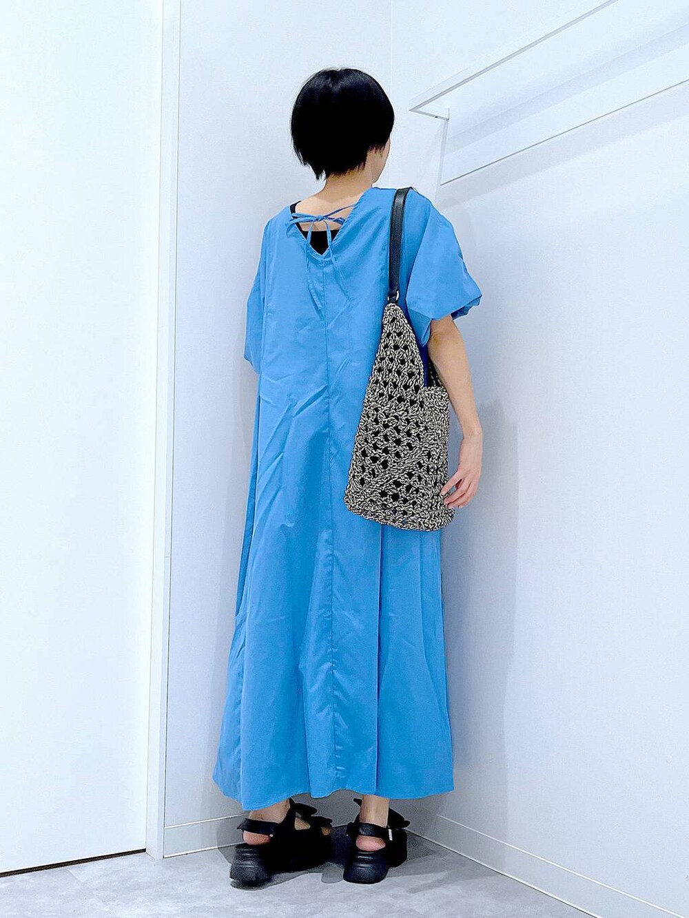 ブラック系のトートバッグ、ブラック系のサンダル、ブルー系のワンピースを着用したレディースの夏コーディネートの5枚目の写真