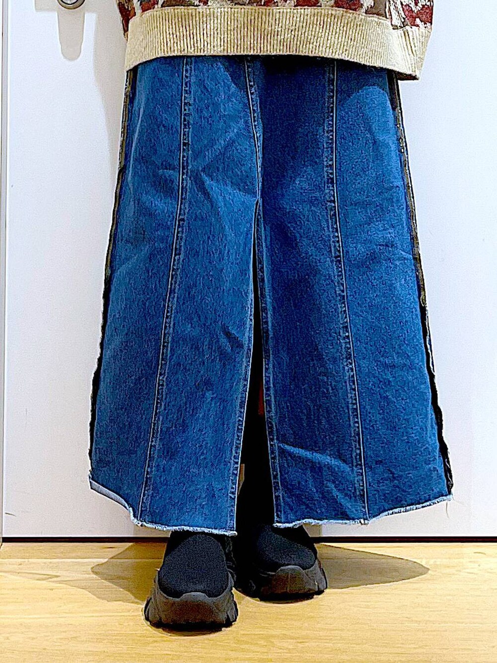 ブラック系のバックパック/リュック、ブルー系のデニムスカート、ブラック系のブーツを着用したレディースの冬コーディネートの8枚目の写真