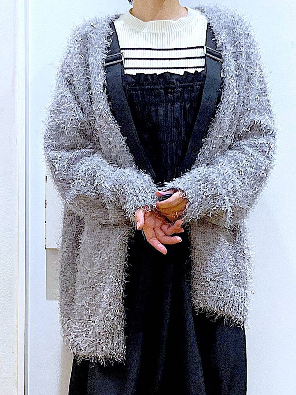 ホワイト系のニット/セーター、ピンク系のショルダーバッグ、グレー系のカーディガン/ボレロを着用したレディースの冬コーディネートの7枚目の写真