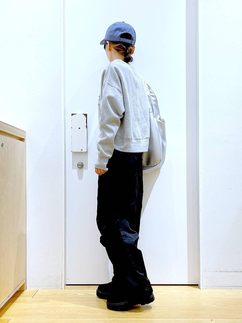 シルバー系のトートバッグ、ブラック系のブーツ、ブラック系のその他パンツを着用したレディースの冬コーディネートの3枚目の写真