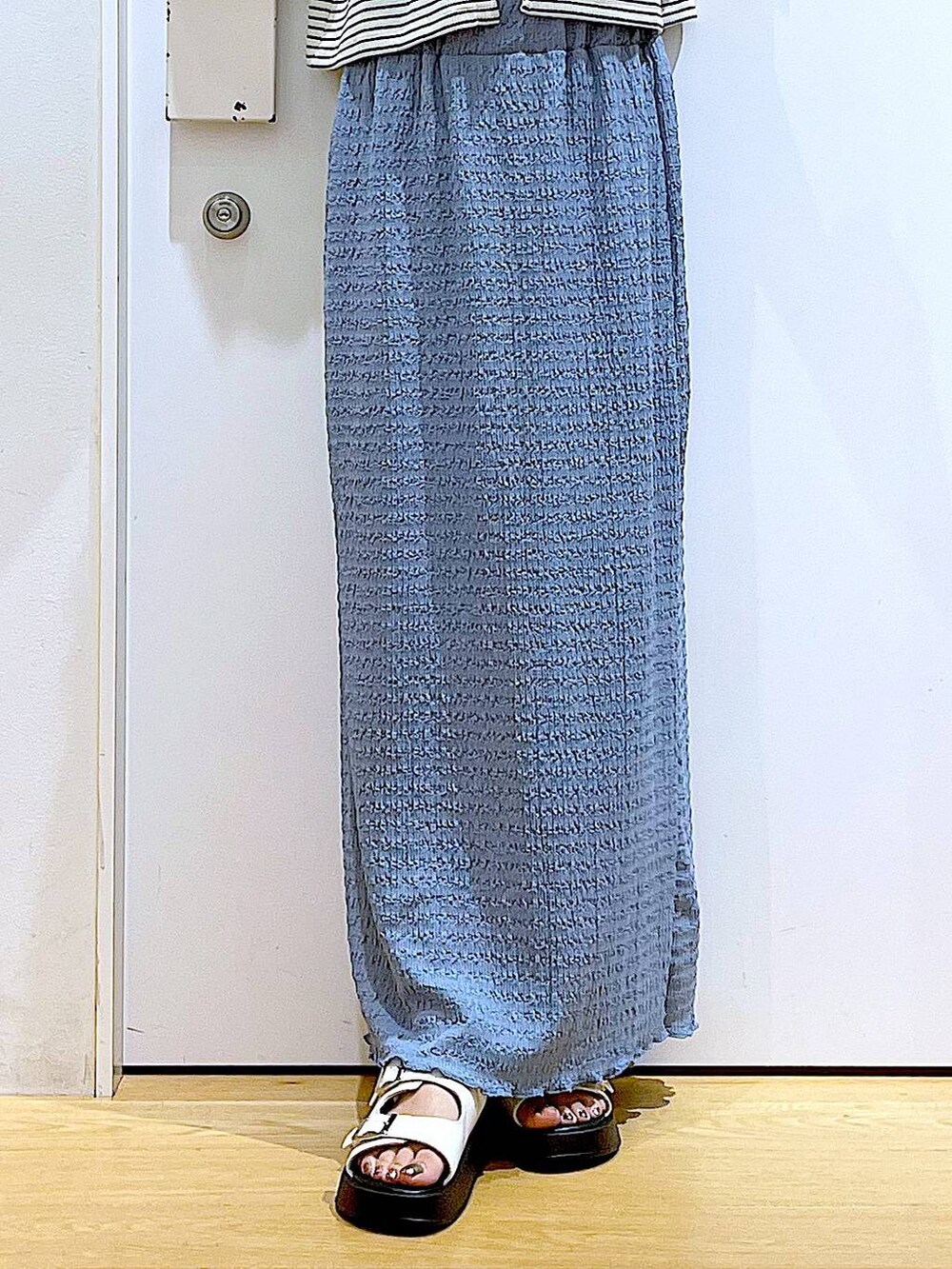 ホワイト系のサンダル、ブルー系のスカート、ホワイト系のショルダーバッグを着用したレディースの秋コーディネートの8枚目の写真