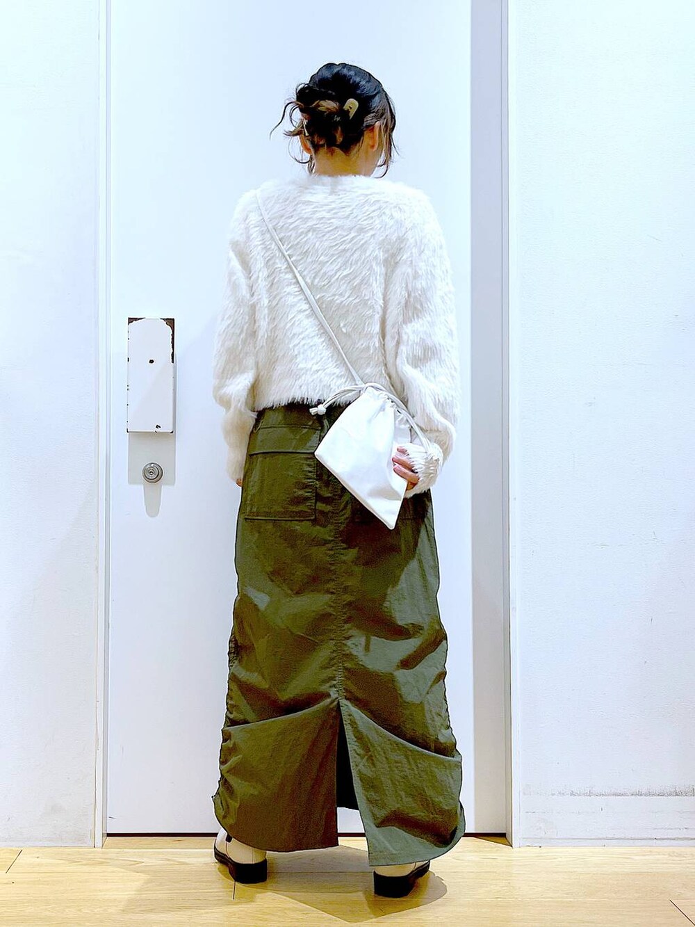 ベージュ系のブーツ、ベージュ系のニット/セーター、グリーン系のスカートを着用したレディースの冬コーディネートの5枚目の写真