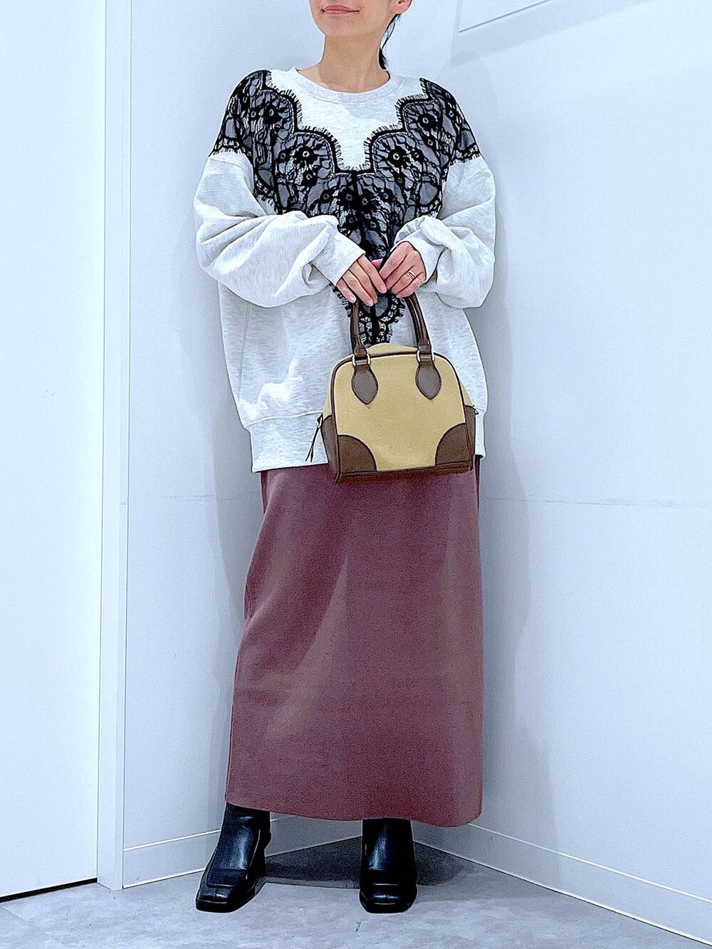 ベージュ系のハンドバッグ、ブラック系のブーツ、ベージュ系のスウェットを着用したレディースの秋コーディネートの6枚目の写真