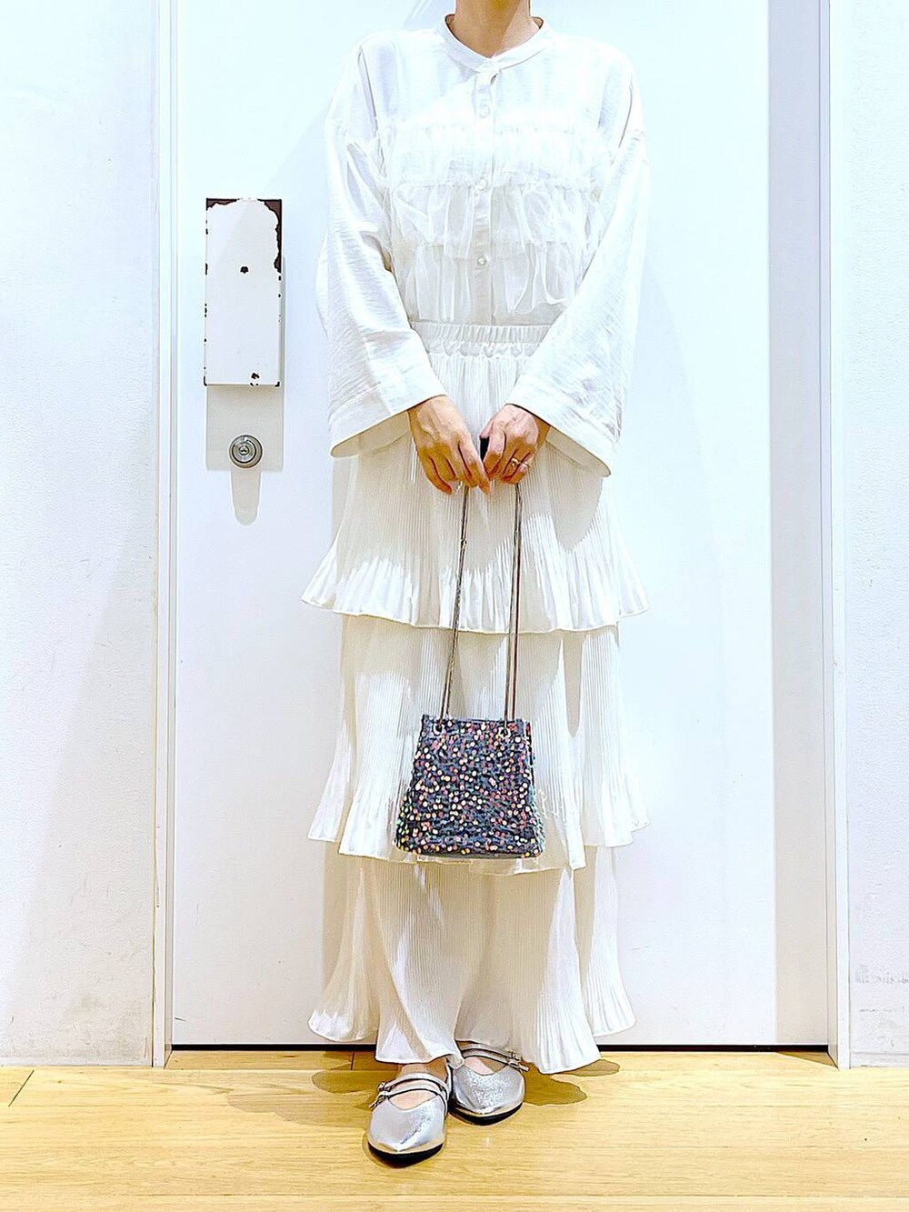 ベージュ系のスカート、シルバー系のパンプス、ホワイト系のシャツ/ブラウスを着用したレディースの秋コーディネートの6枚目の写真