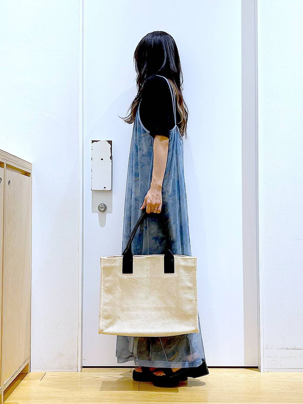 ブラック系のサンダル、ブラック系のその他パンツ、ホワイト系のトートバッグを着用したレディースの夏コーディネートの3枚目の写真