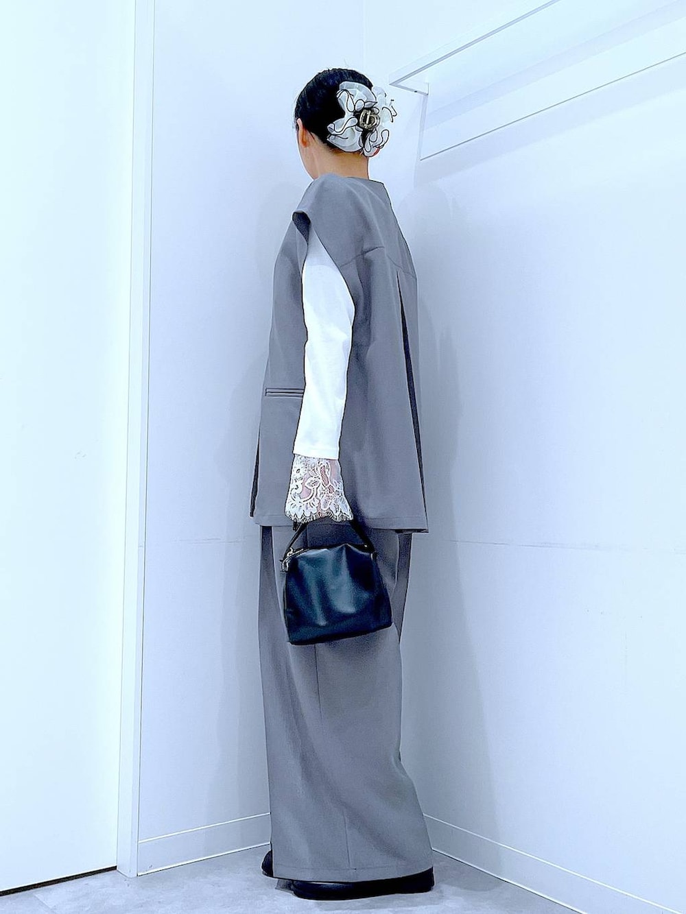 ブラック系のショルダーバッグ、グレー系のサロペット/オーバーオール、グレー系のベストを着用したレディースの冬コーディネートの3枚目の写真