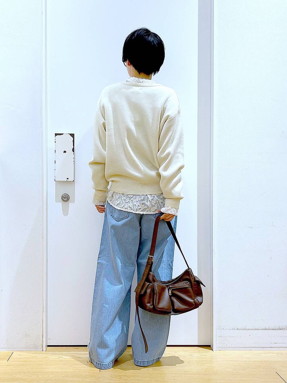 シルバー系のローファー、ブラウン系のショルダーバッグ、ホワイト系のニット/セーターを着用したレディースの春コーディネートの5枚目の写真