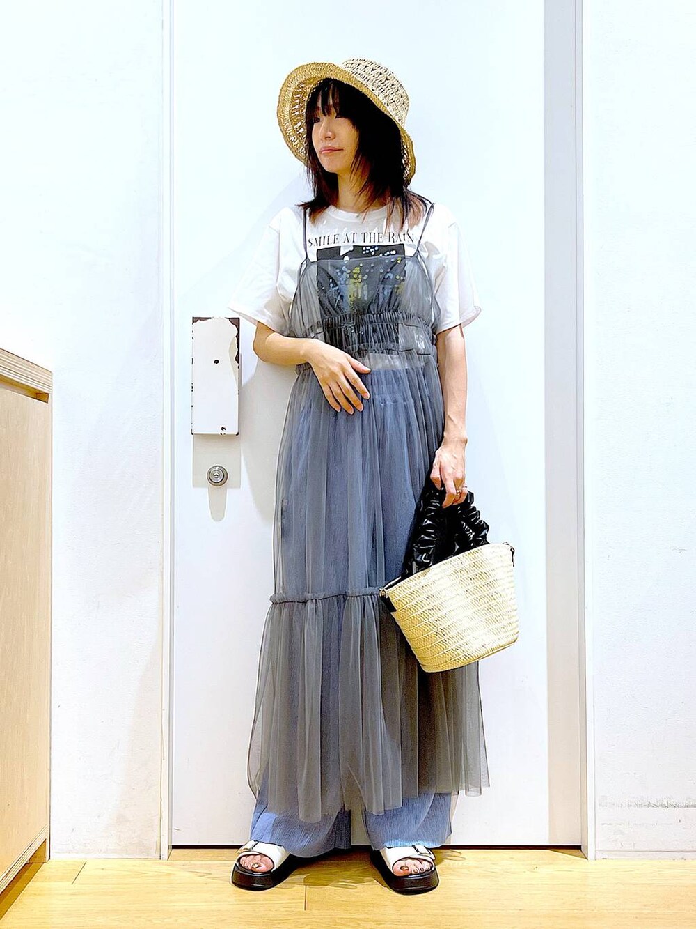 グレー系のワンピース、ホワイト系のショルダーバッグ、ホワイト系のサンダルを着用したレディースの夏コーディネートの2枚目の写真