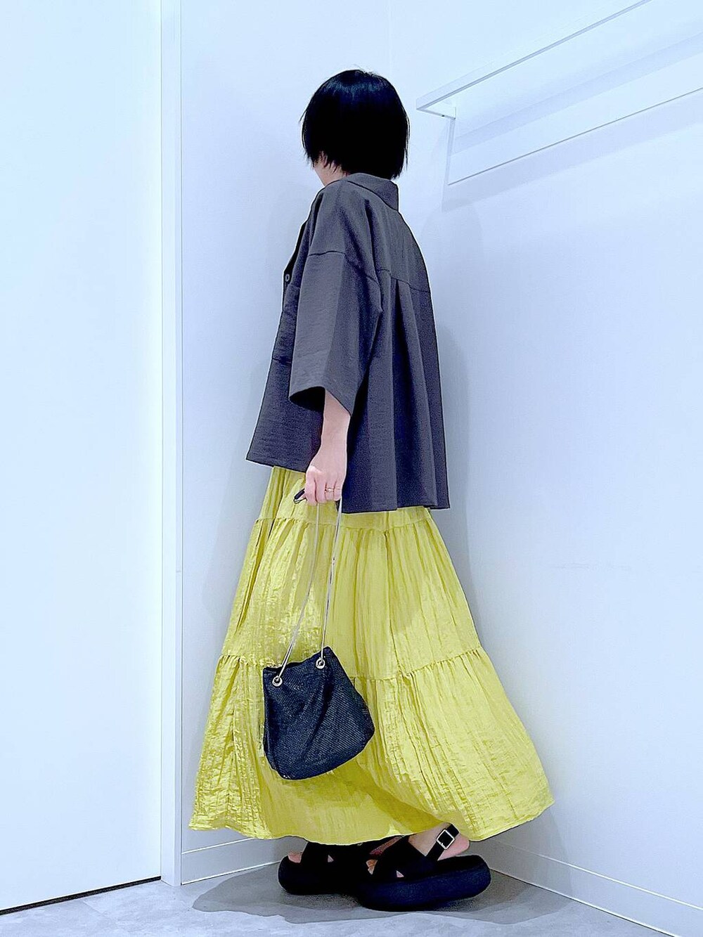 ブラック系のショルダーバッグ、その他のTシャツ/カットソー、ブラック系のサンダルを着用したレディースの夏コーディネートの3枚目の写真