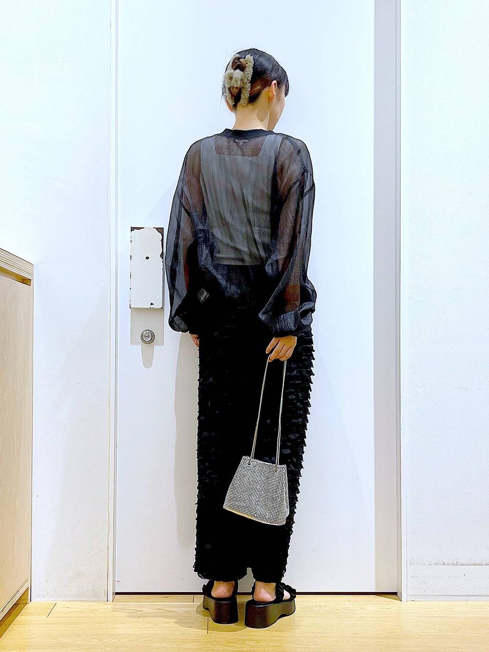 ブラック系のサンダル、ブラック系のブルゾン、ホワイト系のニット/セーターを着用したレディースの夏コーディネートの5枚目の写真