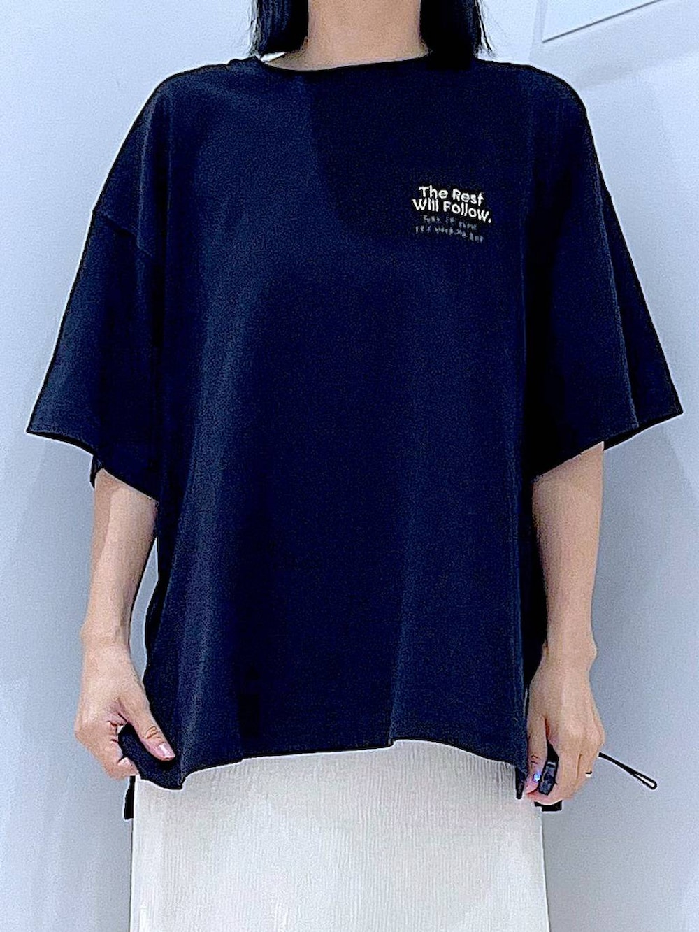 ブラック系のトートバッグ、ホワイト系のサンダル、ブラック系のTシャツ/カットソーを着用したレディースの夏コーディネートの7枚目の写真