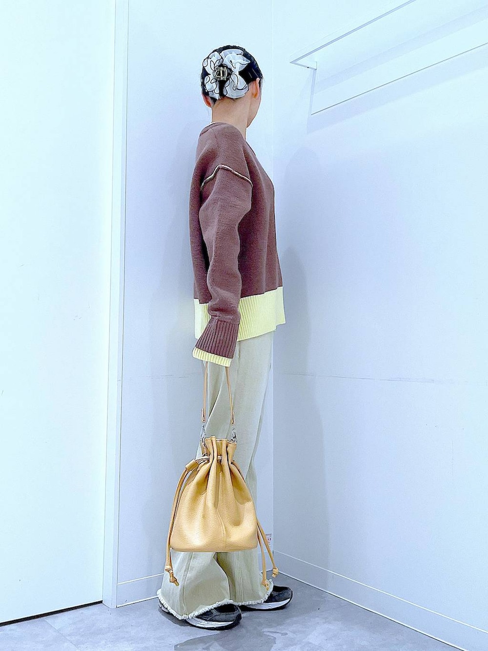 ブラウン系のニット/セーター、ベージュ系のデニムパンツ、ブラウン系のショルダーバッグを着用したレディースの冬コーディネートの4枚目の写真