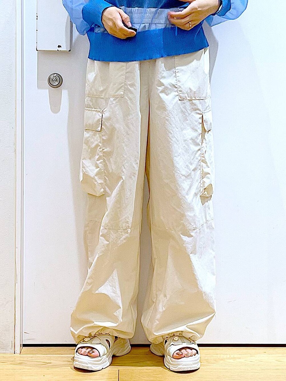 シルバー系のショルダーバッグ、ホワイト系のカーゴパンツ、ブラック系のニット/セーターを着用したレディースの夏コーディネートの8枚目の写真