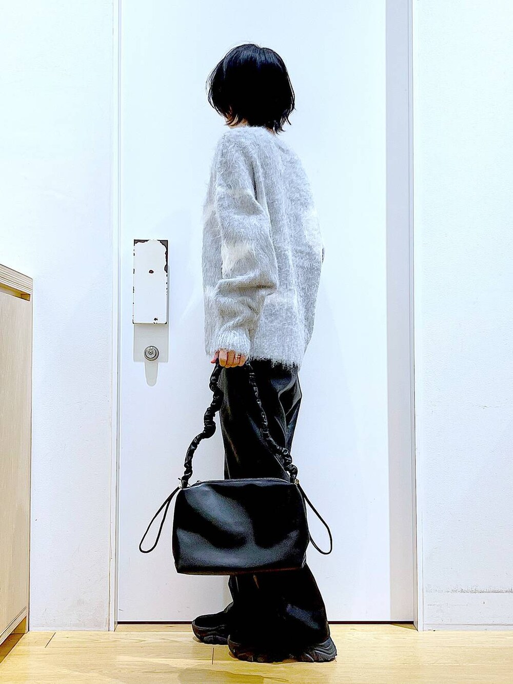 グレー系のニット/セーター、ブラック系のブーツ、ブラック系のその他パンツを着用したレディースの冬コーディネートの3枚目の写真