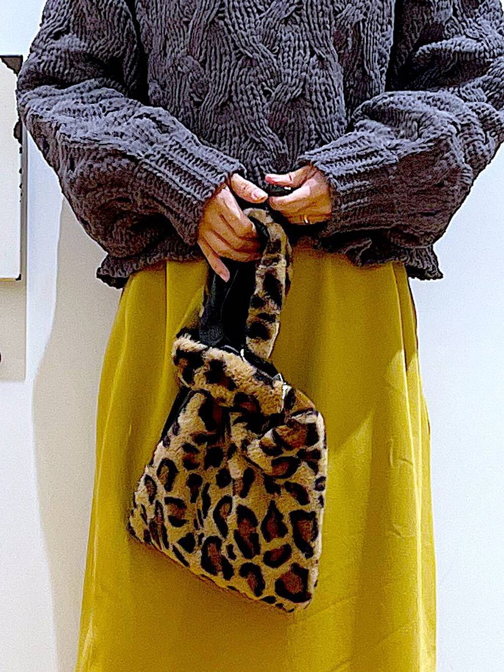 その他のショルダーバッグ、ブラック系のブーツ、グレー系のニット/セーターを着用したレディースの冬コーディネートの9枚目の写真