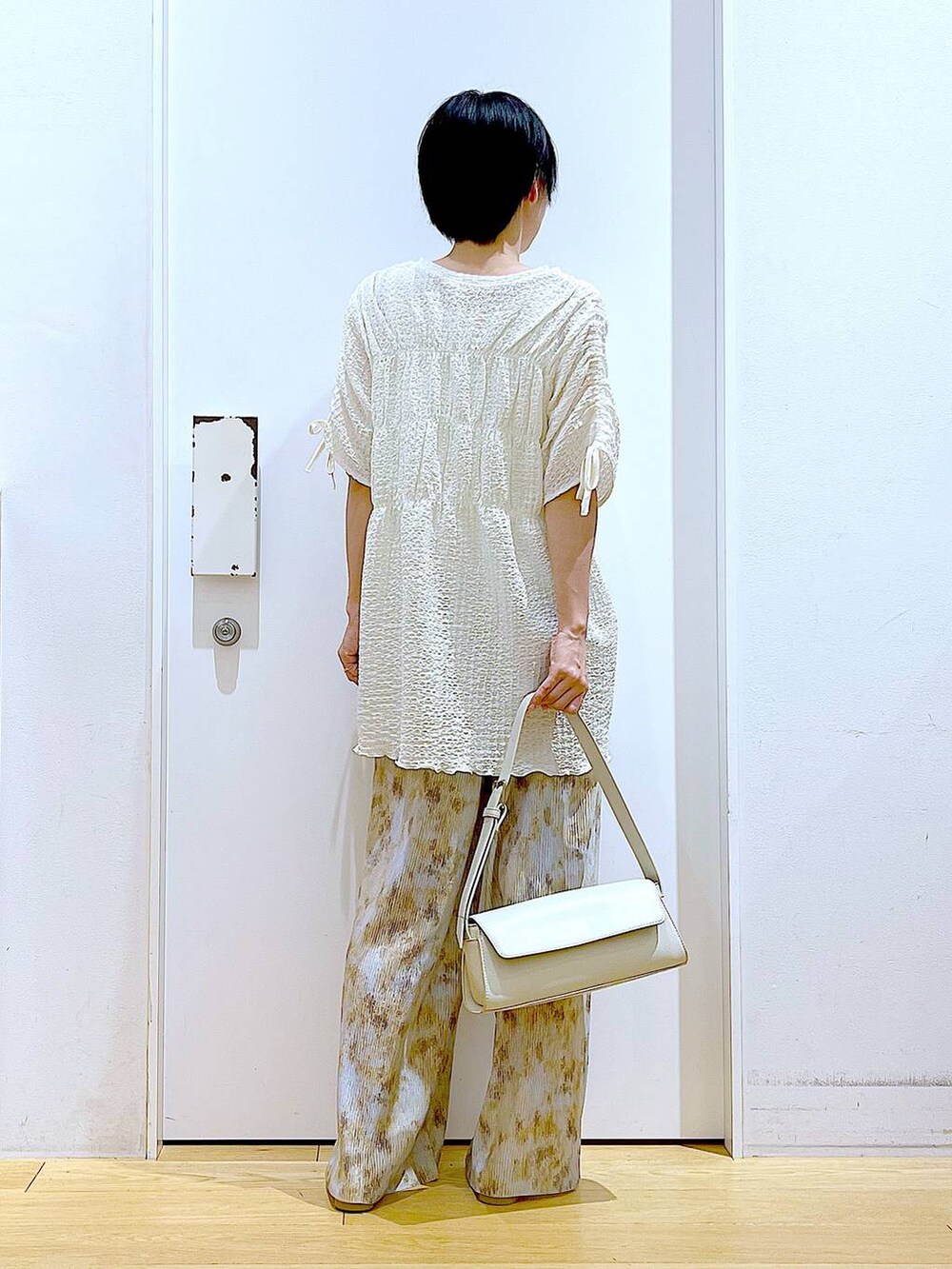 シルバー系のパンプス、ホワイト系のショルダーバッグ、ベージュ系のその他パンツを着用したレディースの春コーディネートの5枚目の写真