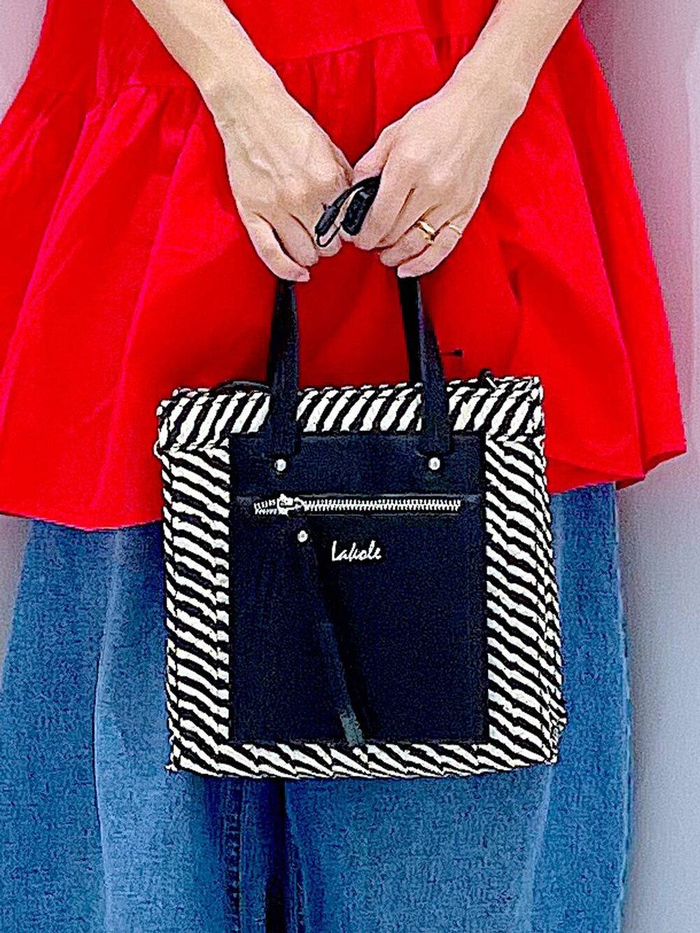 ブルー系のデニムパンツ、ブラック系のショルダーバッグ、シルバー系のサンダルを着用したレディースの夏コーディネートの9枚目の写真