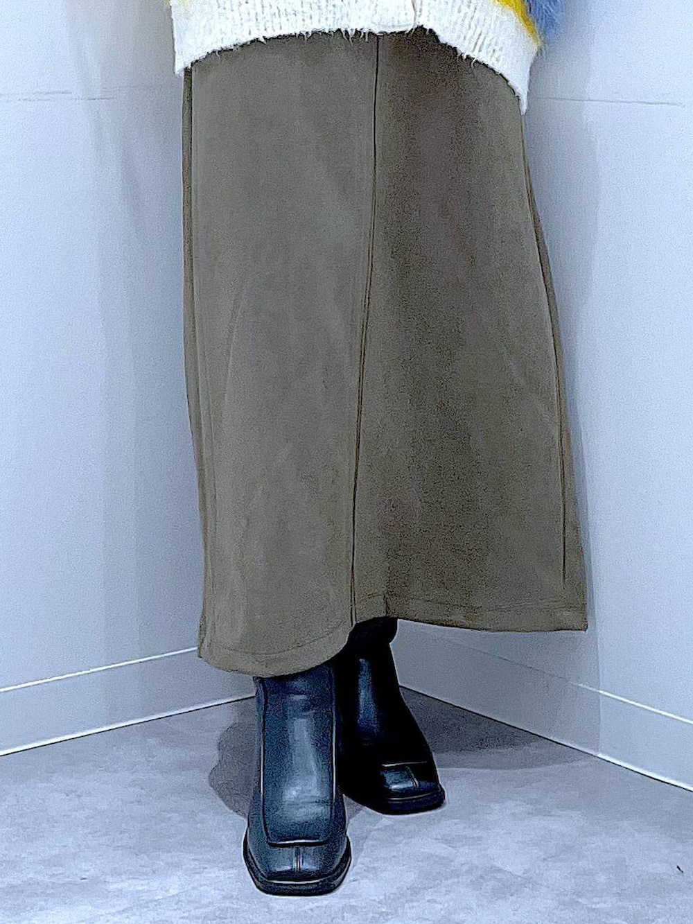 イエロー系のカーディガン/ボレロ、ブラック系のブーツ、グリーン系のスカートを着用したレディースの冬コーディネートの8枚目の写真