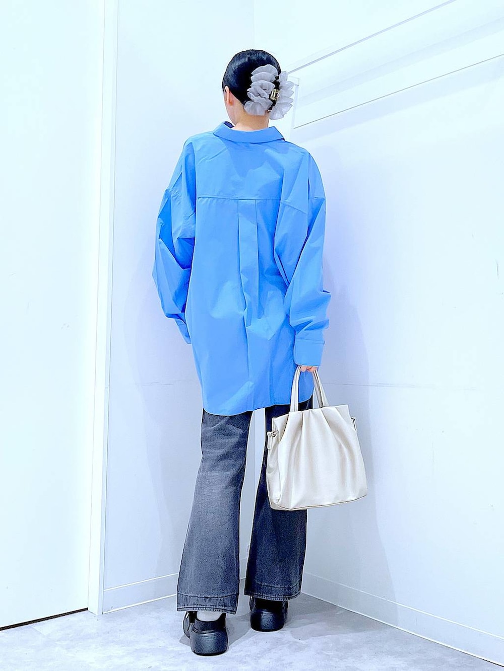 ブラック系のデニムパンツ、ブルー系のシャツ/ブラウス、ホワイト系のTシャツ/カットソーを着用したレディースの秋コーディネートの5枚目の写真