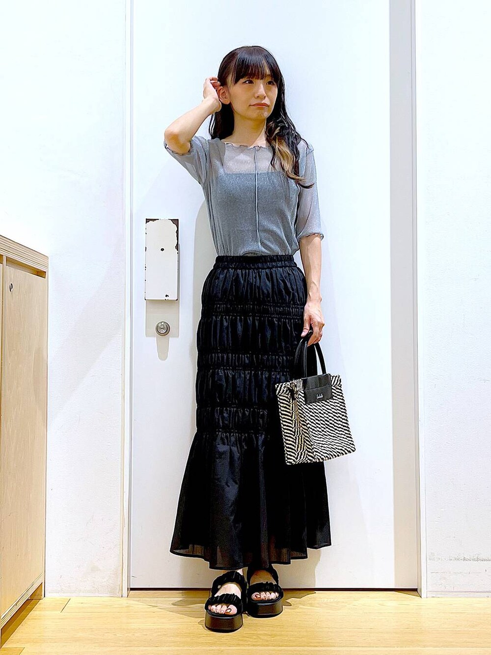 ブラック系のサンダル、ブラック系のショルダーバッグ、ブルー系のTシャツ/カットソーを着用したレディースの夏コーディネートの2枚目の写真