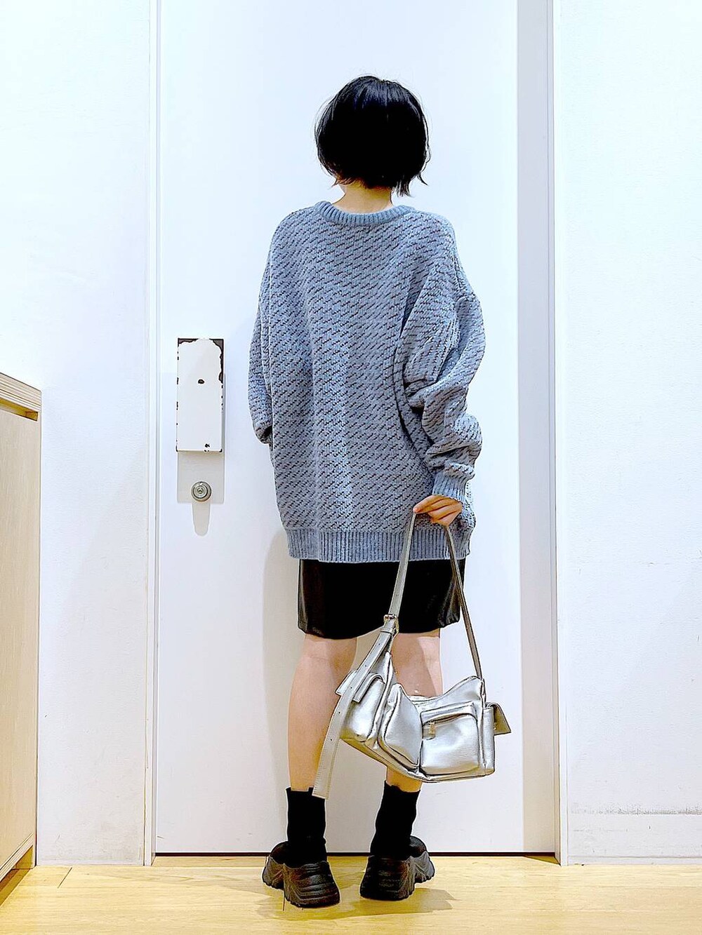 ブルー系のニット/セーター、ブラック系のブーツ、その他のショルダーバッグを着用したレディースの冬コーディネートの5枚目の写真