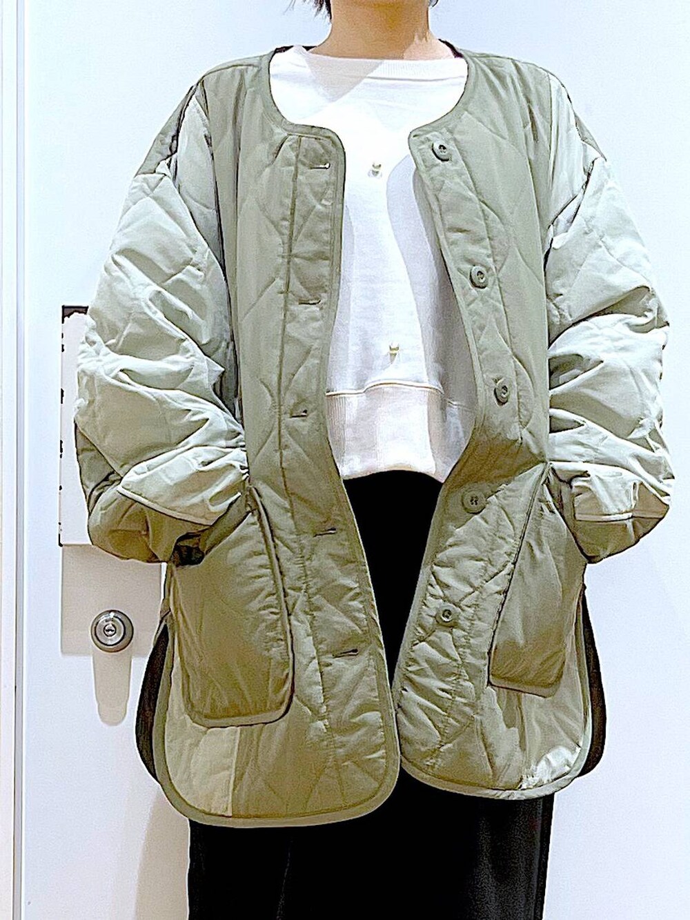 ブラック系のショルダーバッグ、ホワイト系のスウェット、ブラック系のブーツを着用したレディースの秋コーディネートの7枚目の写真