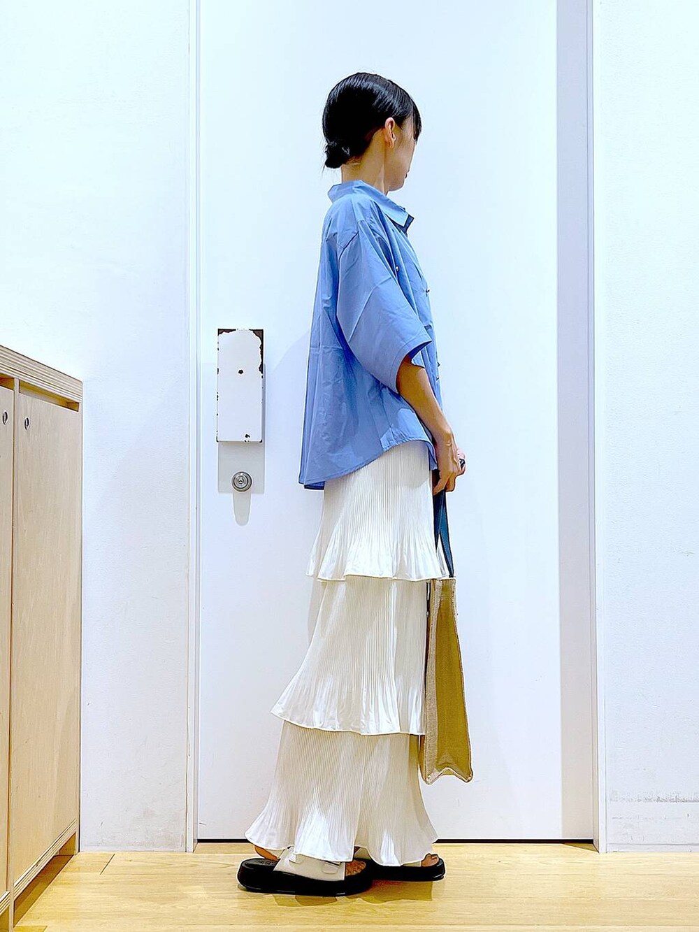 ベージュ系のスカート、ブルー系のトートバッグ、ホワイト系のサンダルを着用したレディースの夏コーディネートの4枚目の写真