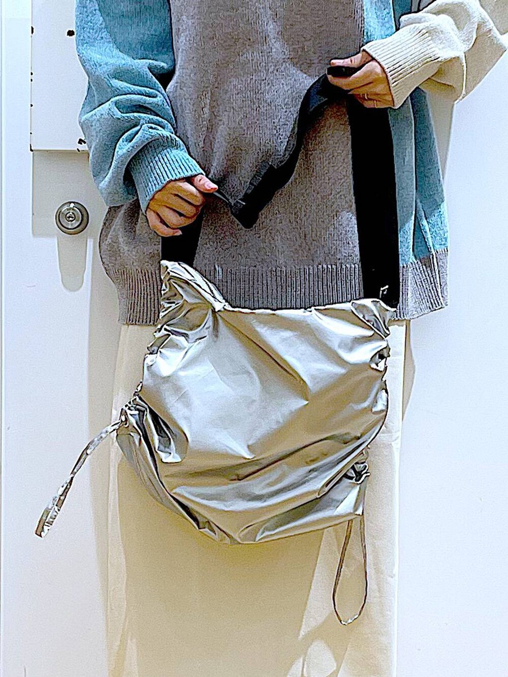 ベージュ系のスニーカー、グレー系のニット/セーター、ベージュ系のスカートを着用したレディースの冬コーディネートの9枚目の写真