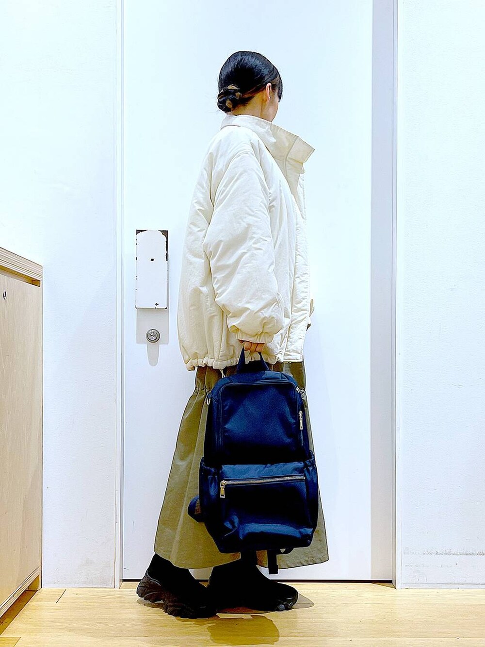 ブルー系のバックパック/リュック、ブラック系のブーツ、グレー系のスウェットを着用したレディースの冬コーディネートの4枚目の写真