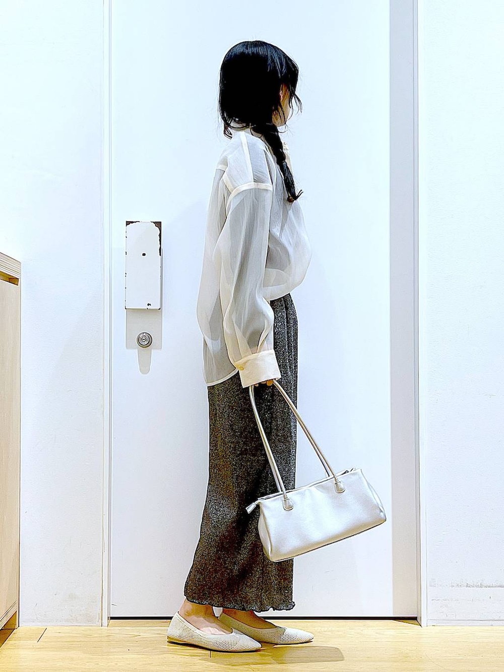 ブラック系のスカート、ホワイト系のパンプス、ホワイト系のシャツ/ブラウスを着用したレディースの春コーディネートの4枚目の写真